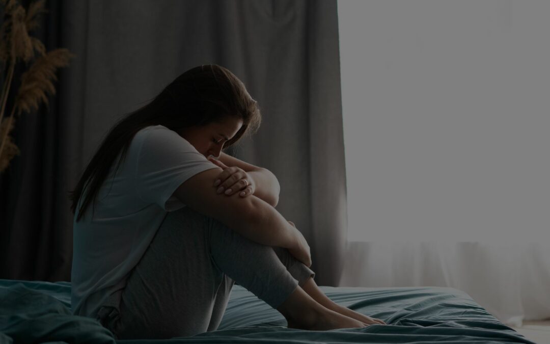 woman with past trauma sitting on the bed